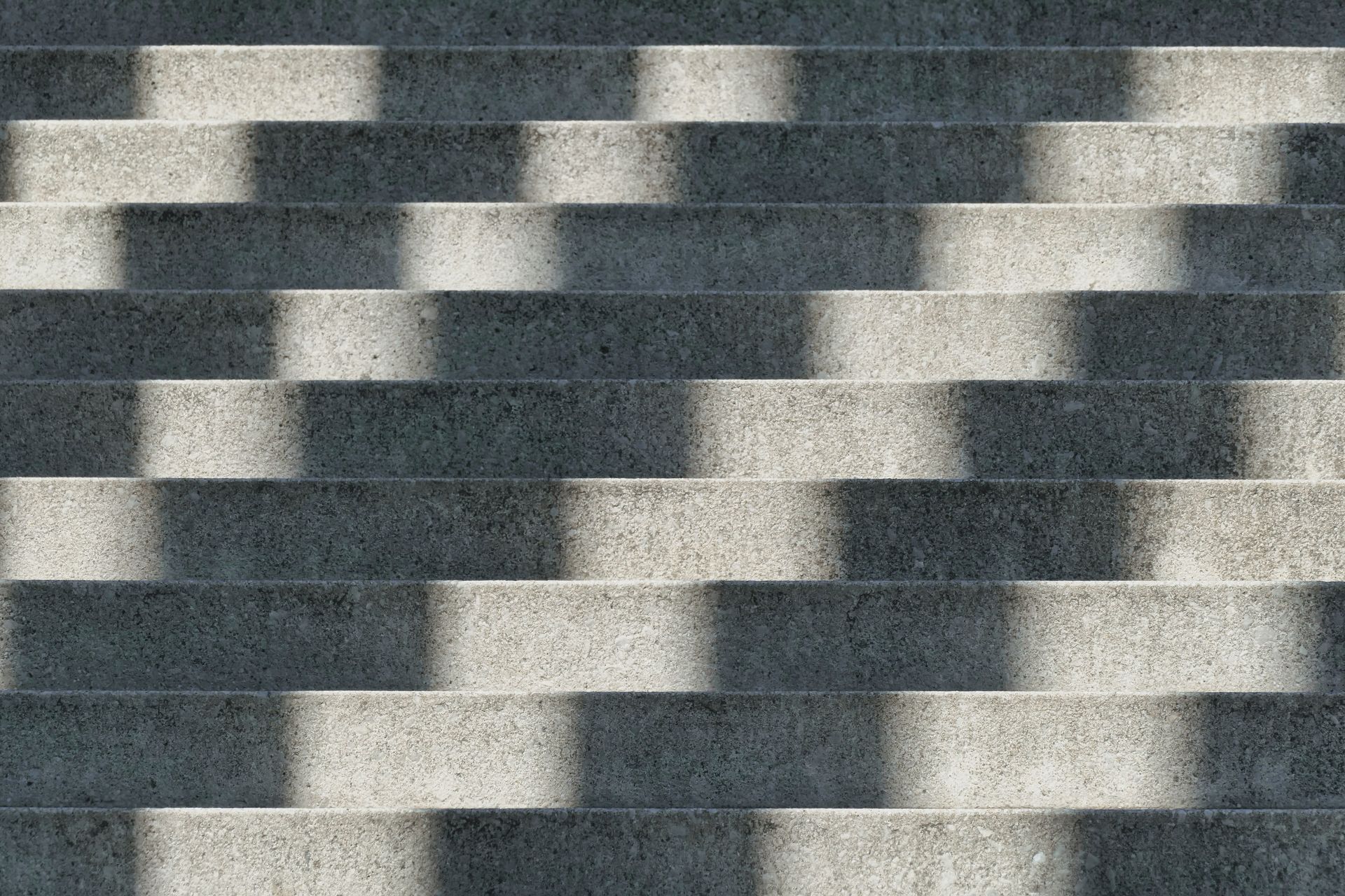 Captivating abstract image of shadows cast on concrete stairs in Berlin, showcasing geometric patterns.